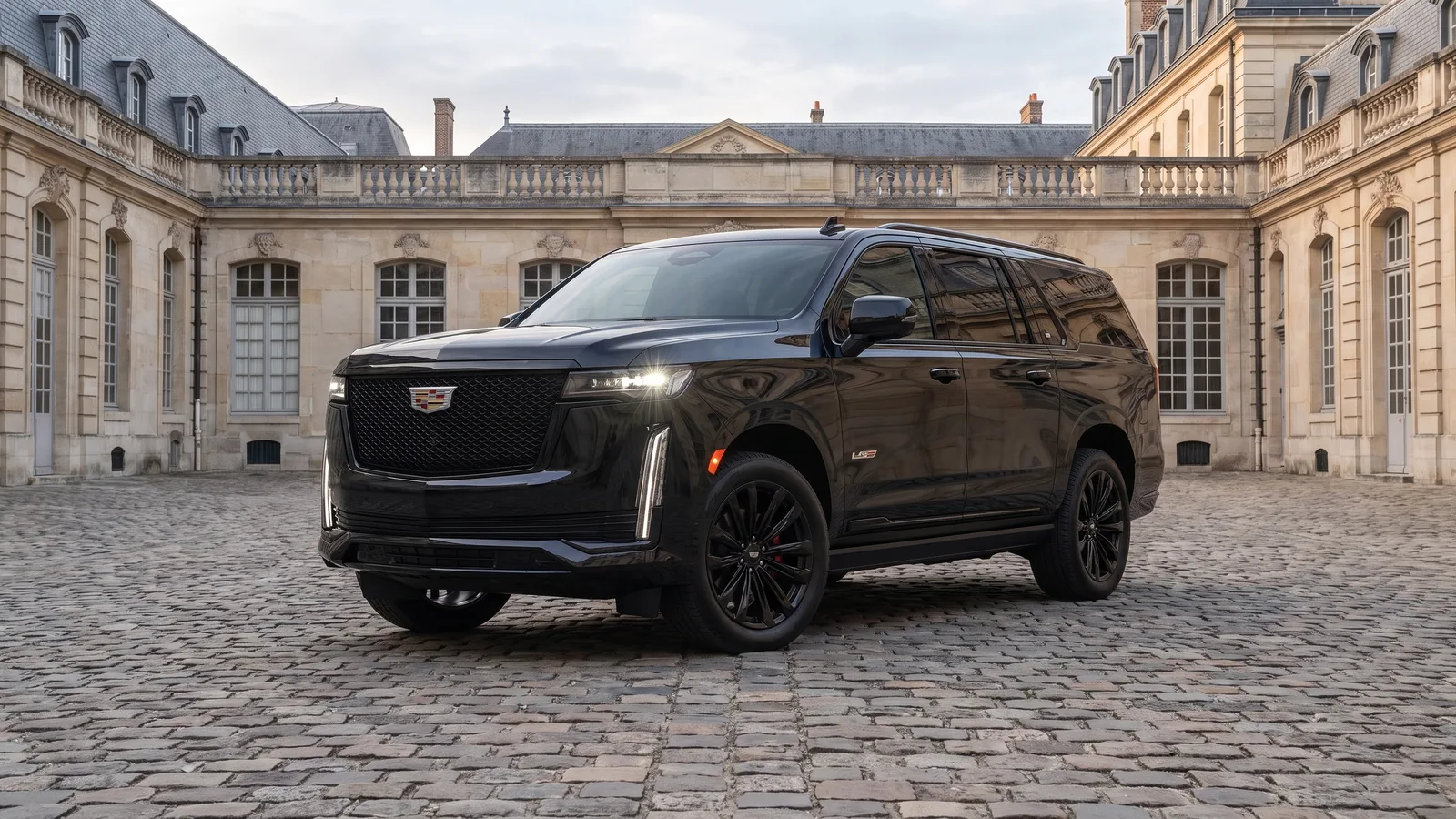 Cadillac Escalade noire, trois quarts avant, dans la cour pavée d'un hôtel particulier parisien