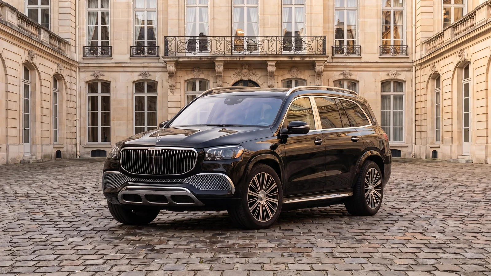 Mercedes-Maybach GLS 600 noir, trois quarts avant, dans la cour pavée d'un hôtel particulier parisien